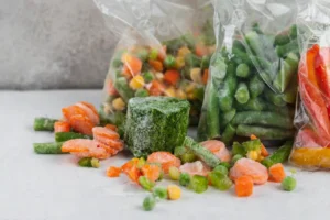 Tampilan close-up sayuran beku yang dikemas dalam berbagai jenis plastik untuk kemasan frozen food.